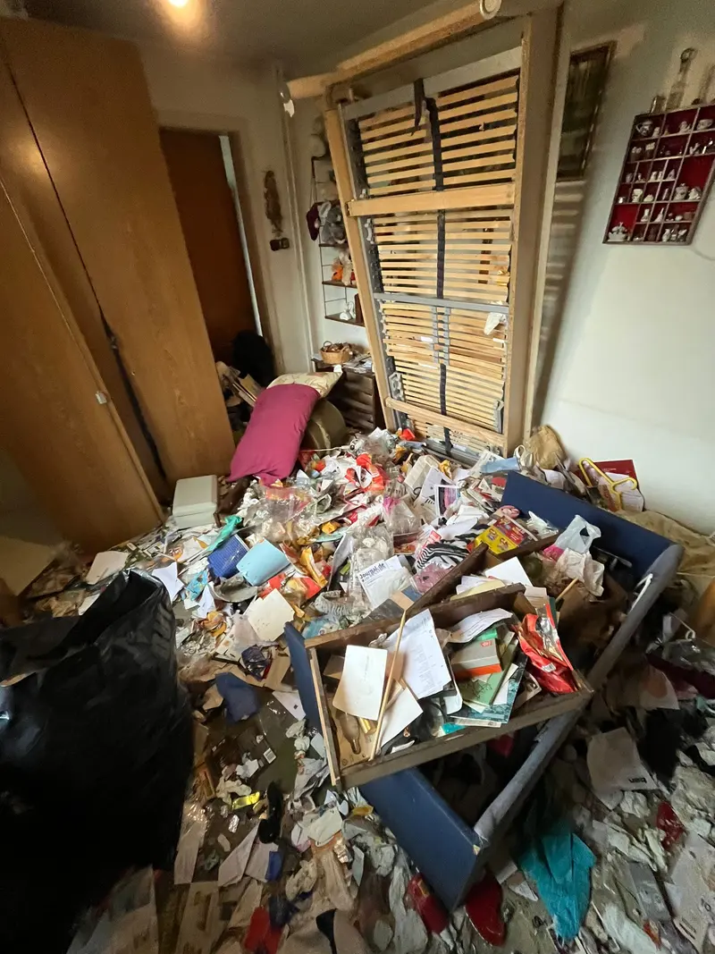 Pièce avec papiers et déchets au sol avant débarras