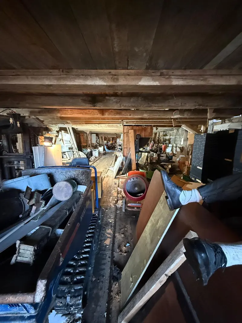 Intérieur de l'ancienne scierie encombré de matériel avant débarras