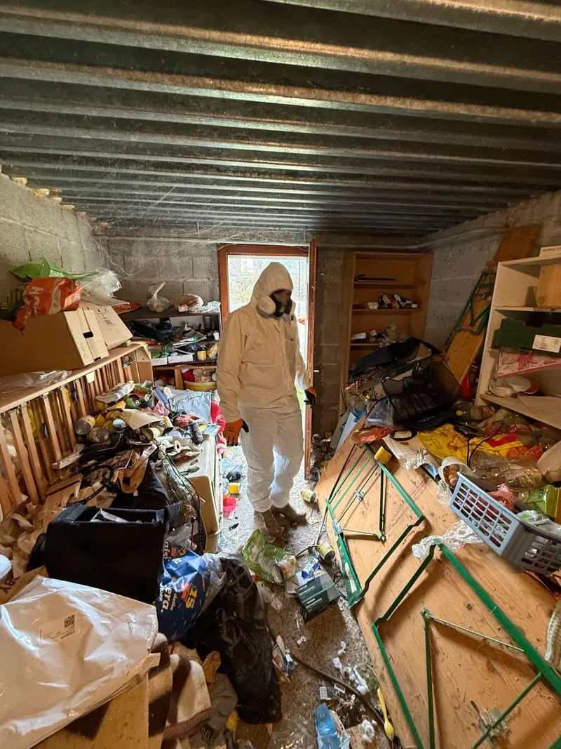 Intervenant en combinaison de protection dans un logement très encombré